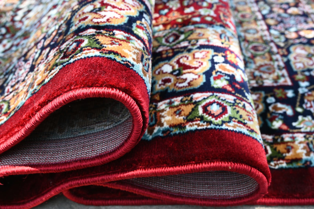 Close-up of Zebaish Traditional Carpet showing detailed floral motifs in burgundy, navy, ivory, gold and rust