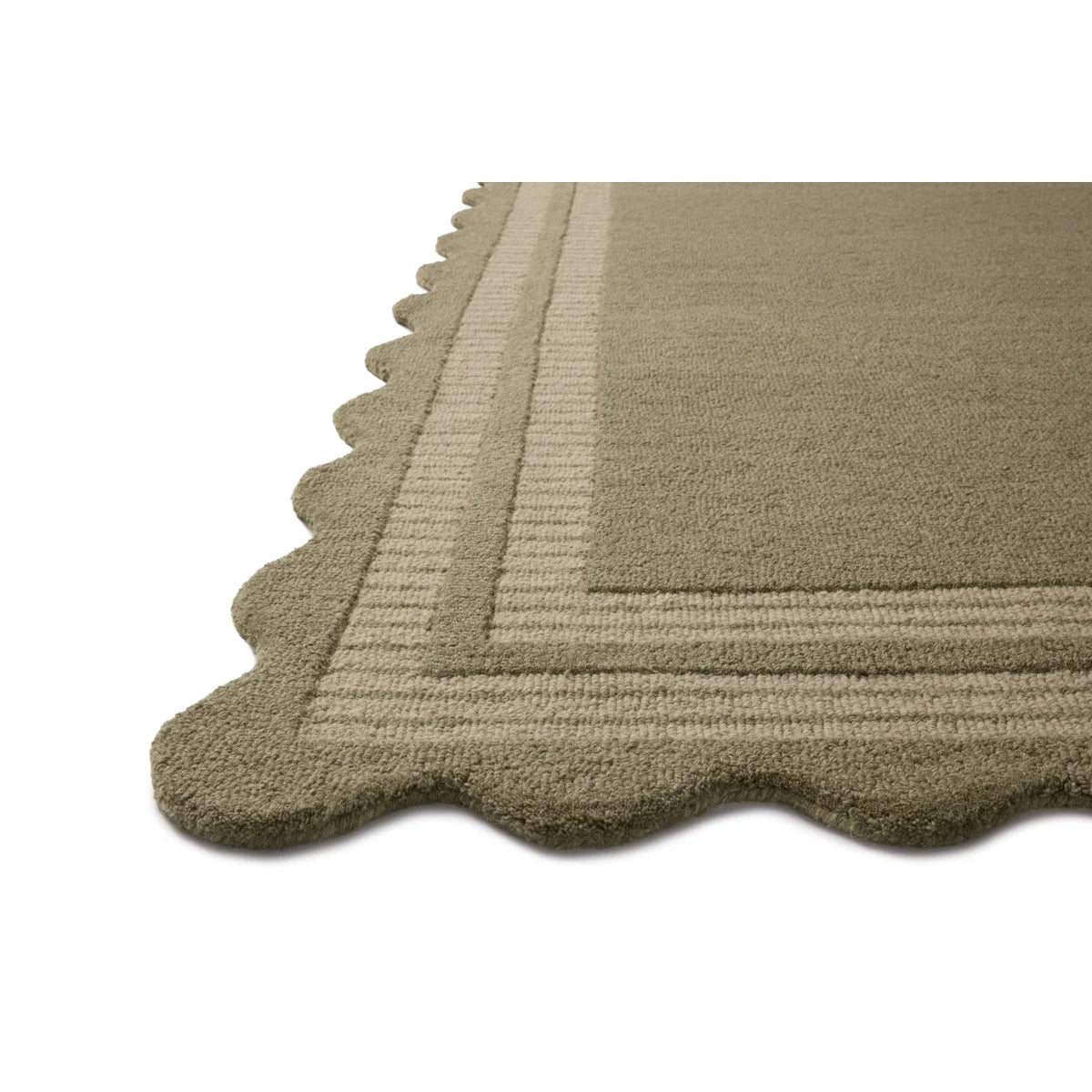 Close-up of a beige rug with a scalloped edge on a white background