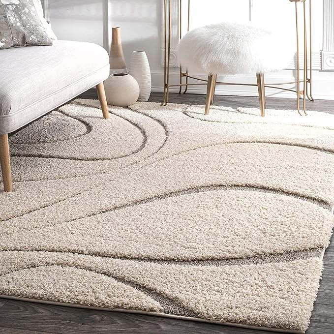 Ivory shaggy rug featuring sculpted flowing wave lines styled in a modern minimalist living room.