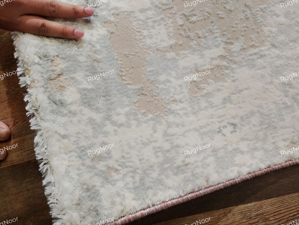 Close-up of the Amselle rug's corner, finished edge and textured surface.