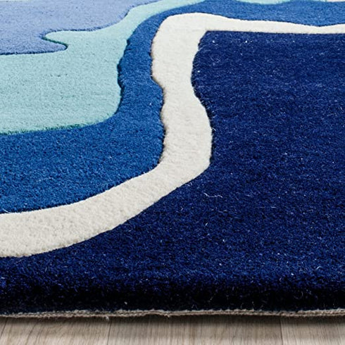 Close-up texture of hand-tufted wool rug in blue and turquoise wave pattern
