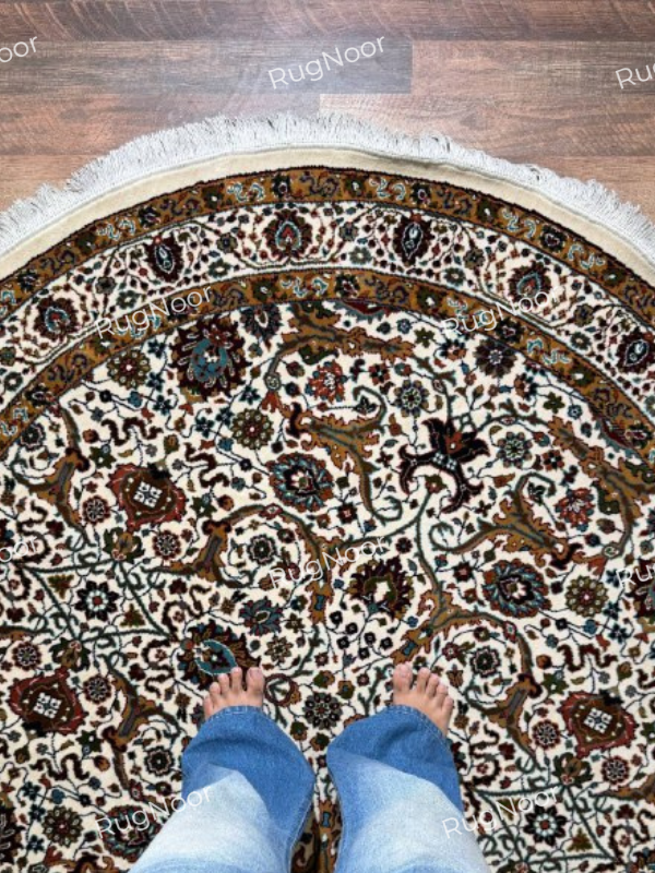Close-up of ivory round traditional rug with intricate brown, rust and teal floral motifs - Zarqaya RugNoor