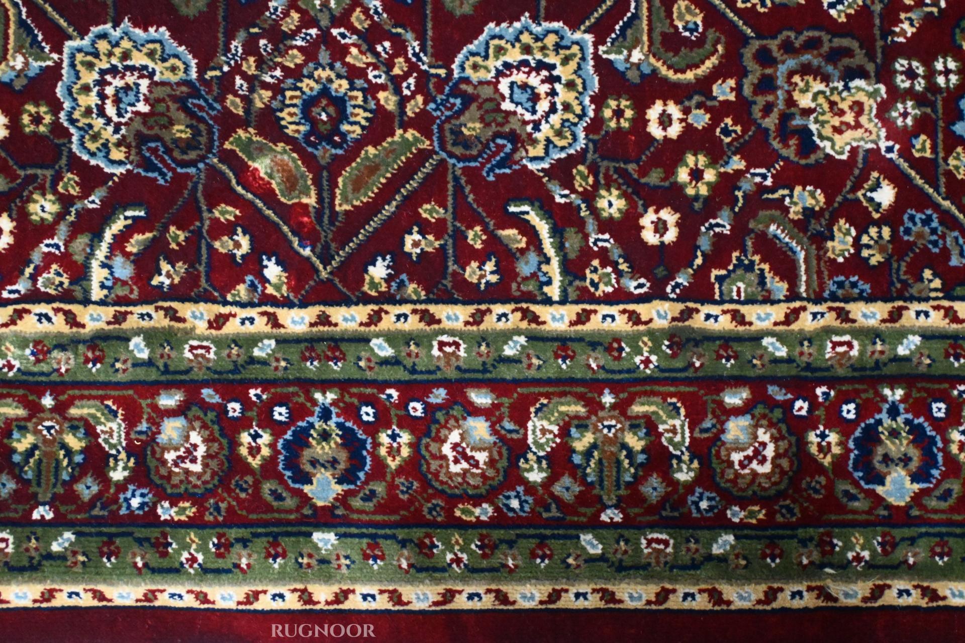 Close-up of Firman Persian rug forest green border stripe showing layered floral motifs in green, gold and ivory