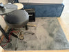 Grey furrug used as floor mat in music practice room with drum kit