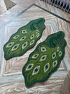 Pair of green peacock shaped rugs placed on marble floor