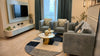 Modern living room with gray sofa, coffee table, and TV in a well-lit room.
