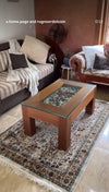 Cream traditional floral persian heritage border rug under wooden coffee table in cozy living room