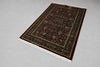 Firman Persian rug angled view showing full pattern, forest green border and all-over floral arabesque design