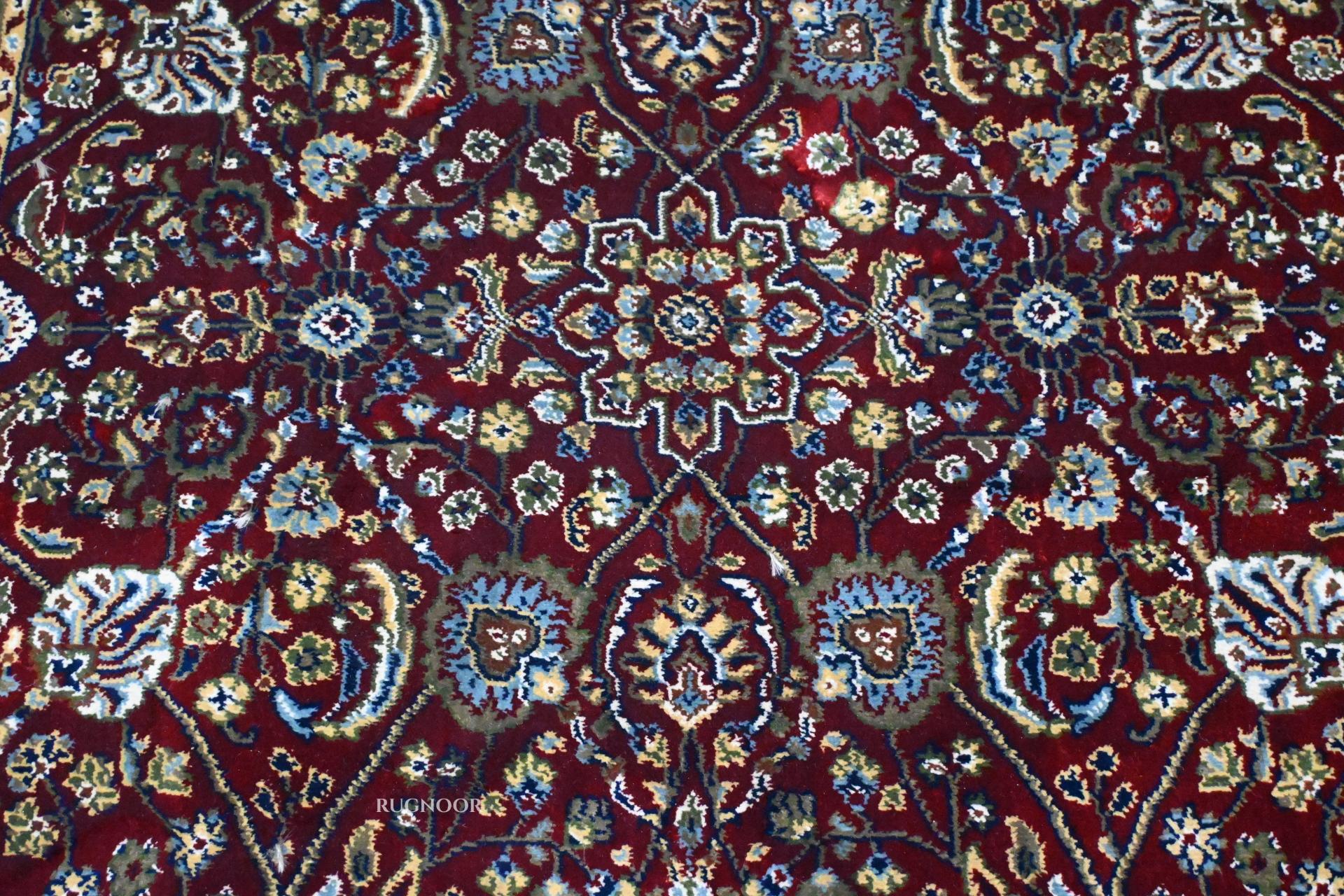 Firman Persian rug centre — dense all-over floral arabesque in deep crimson with blue, green, gold and ivory accents