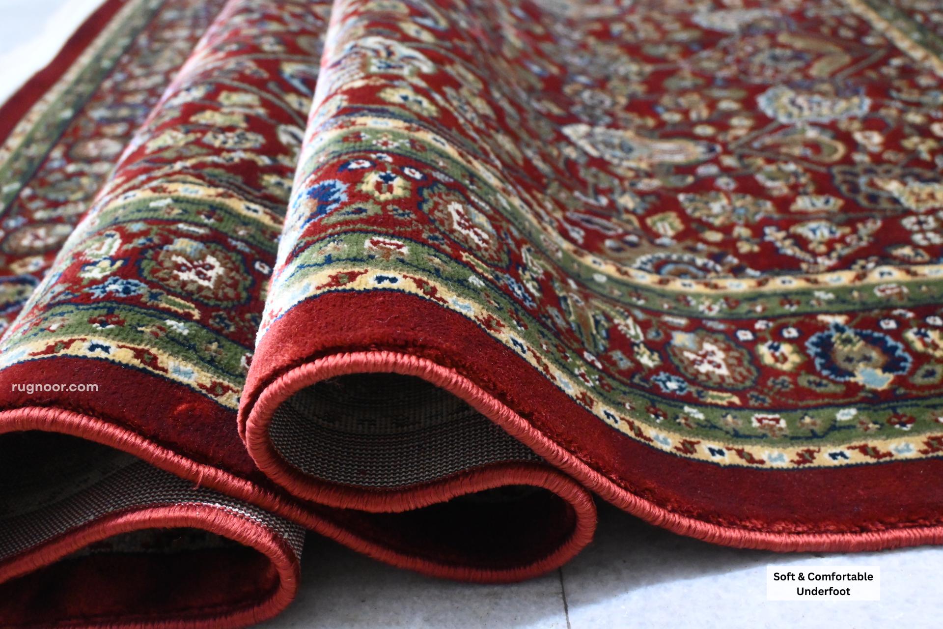 Firman Persian rug folded showing soft acrylic wool pile, green-gold border detail and plush comfortable texture