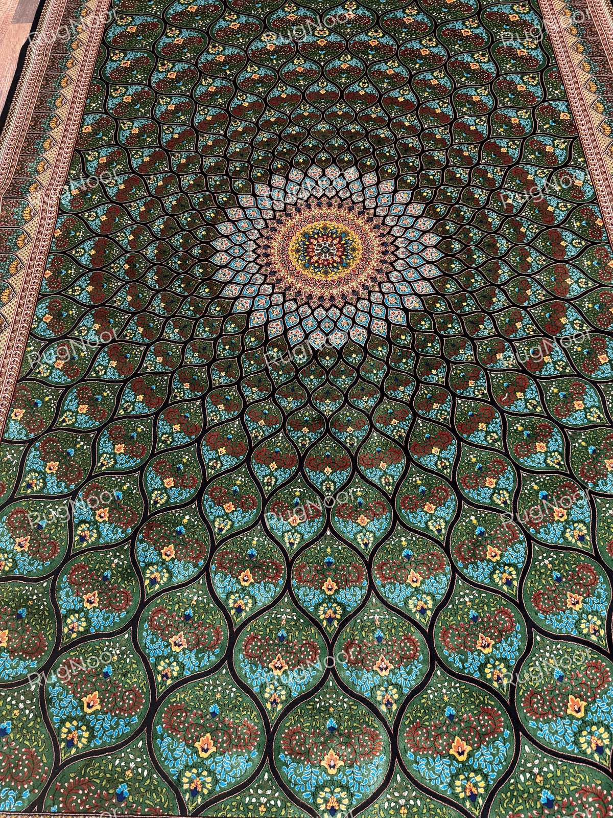 Close-up of the green floral field and contrasting ornate border with turquoise and red accents.