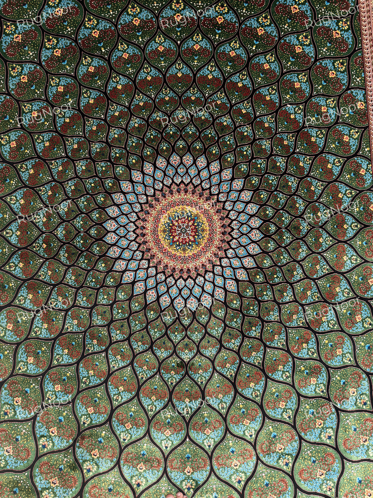 Close-up of the radiating central medallion and dense turquoise, red, yellow and ivory patterning.