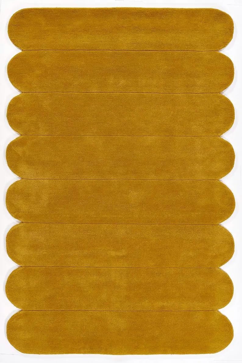 A mustard yellow rectangular rug with rounded, scalloped edges and a plush pile texture, shown flat against a white background.