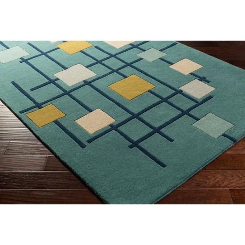 Detailed view of hand tufted wool texture in teal, yellow, and white tones