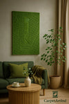 Green textured wall art of Central Park in a living room setting with a sofa and plant.