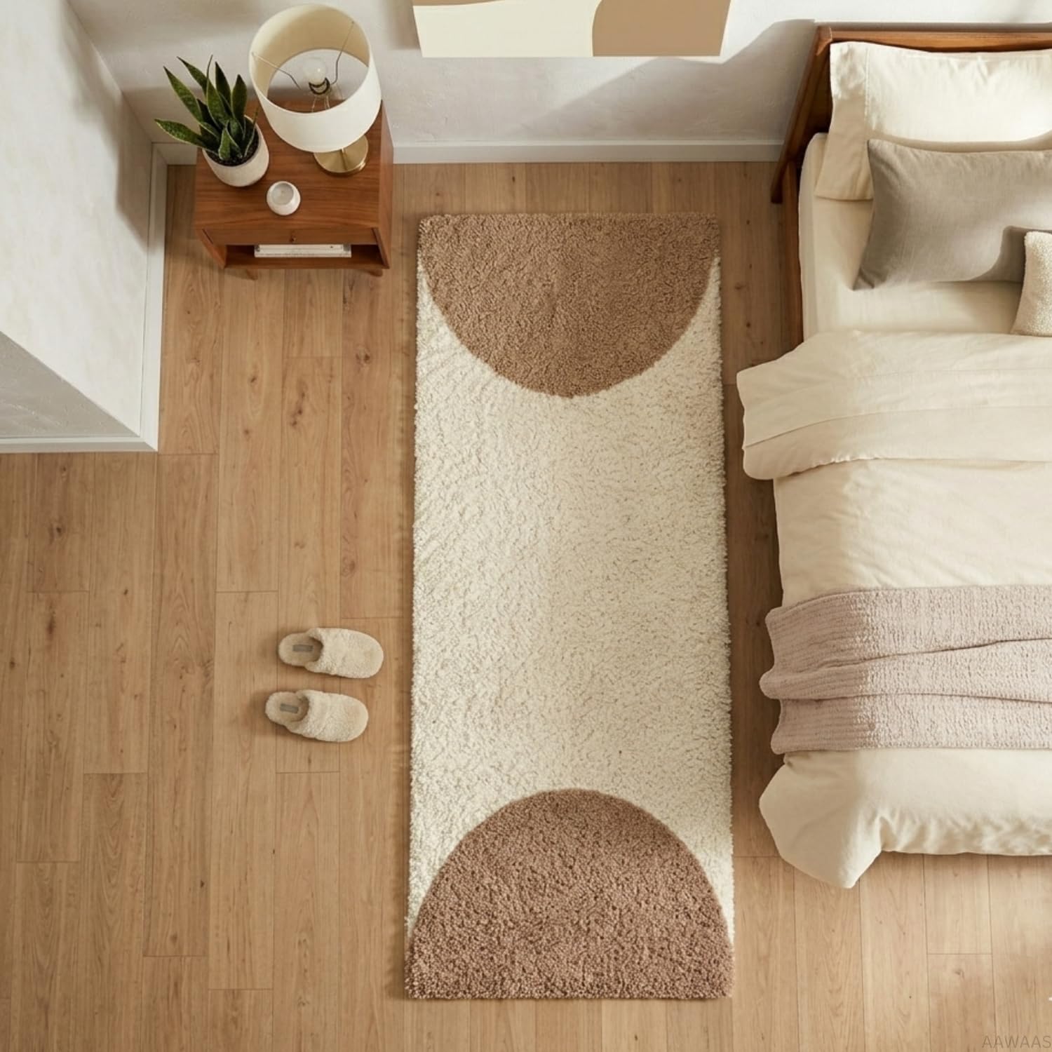 A long rectangular shag rug with two large semi-circular brown sections, shown on a light wood floor next to a bed and bedside table.