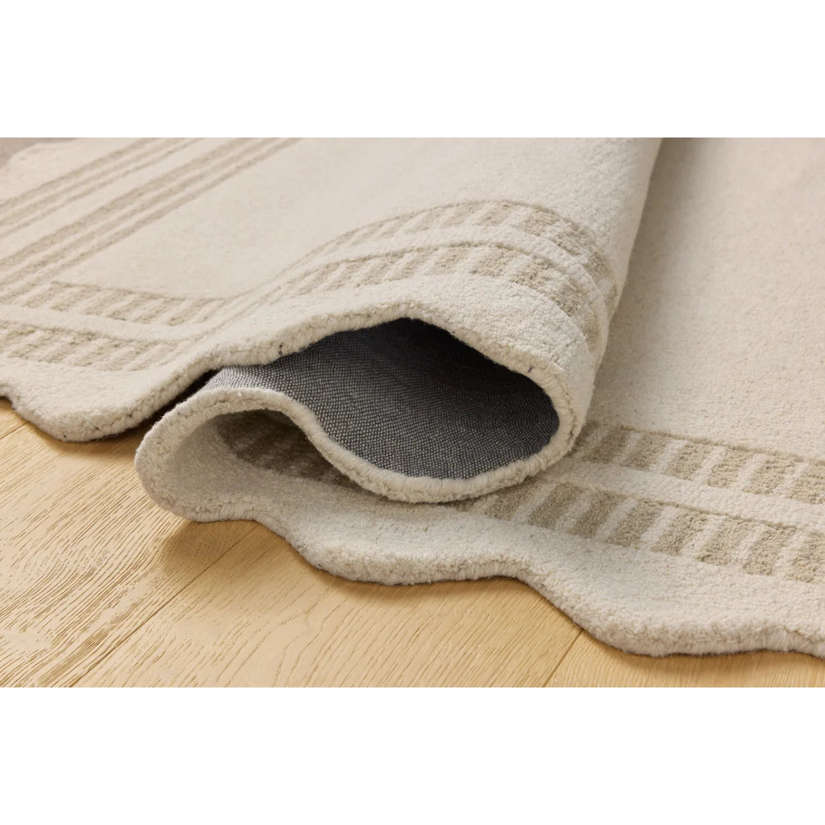 Beige textured rug on a wooden floor