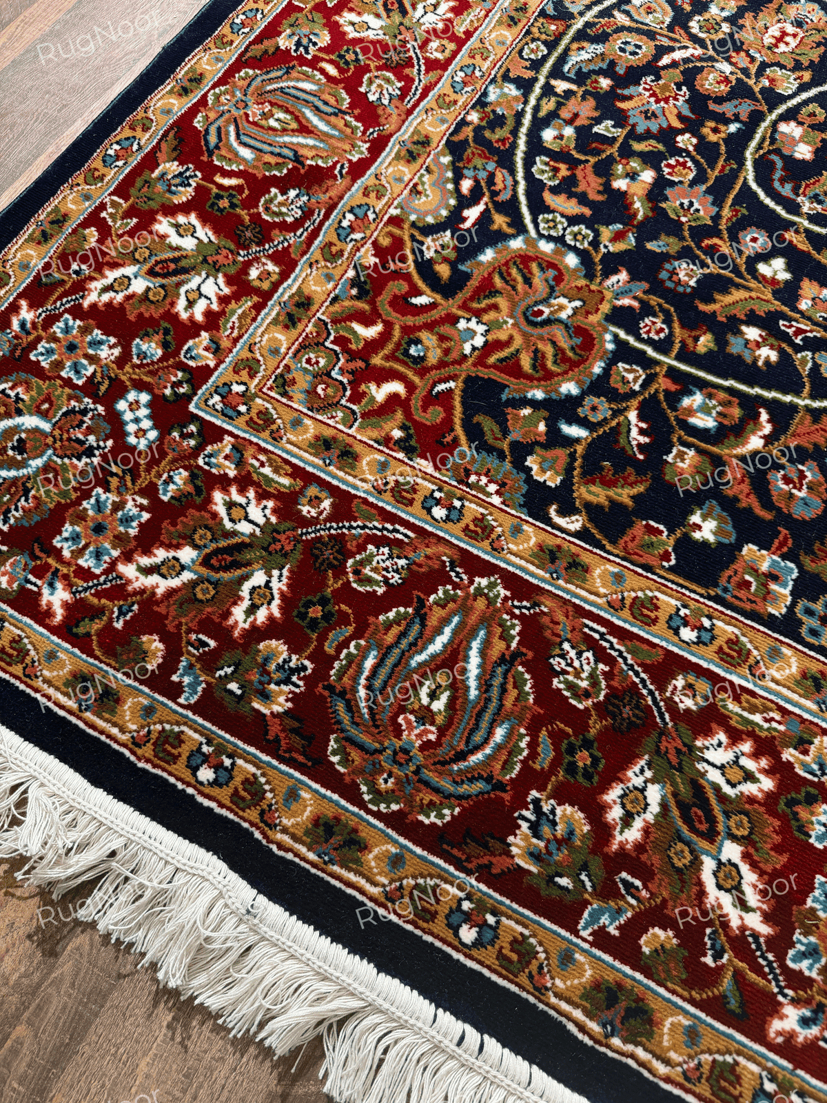 Jouri rug corner showing navy field, red floral border and ivory fringe - RugNoor