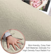 Close-up of a plush, beige rabbit fur carpet with a hand touching it