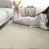 Person lying on a beige rabbit fur carpet in a room