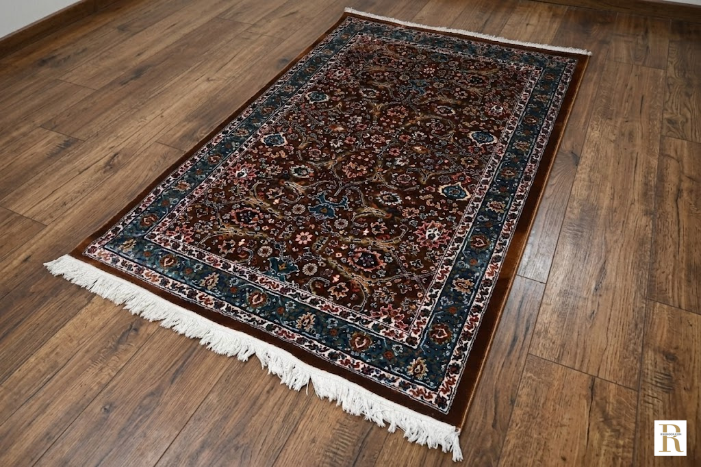 Naqsh Persian rug angled view on wood floor showing full pattern, teal border and cotton fringe