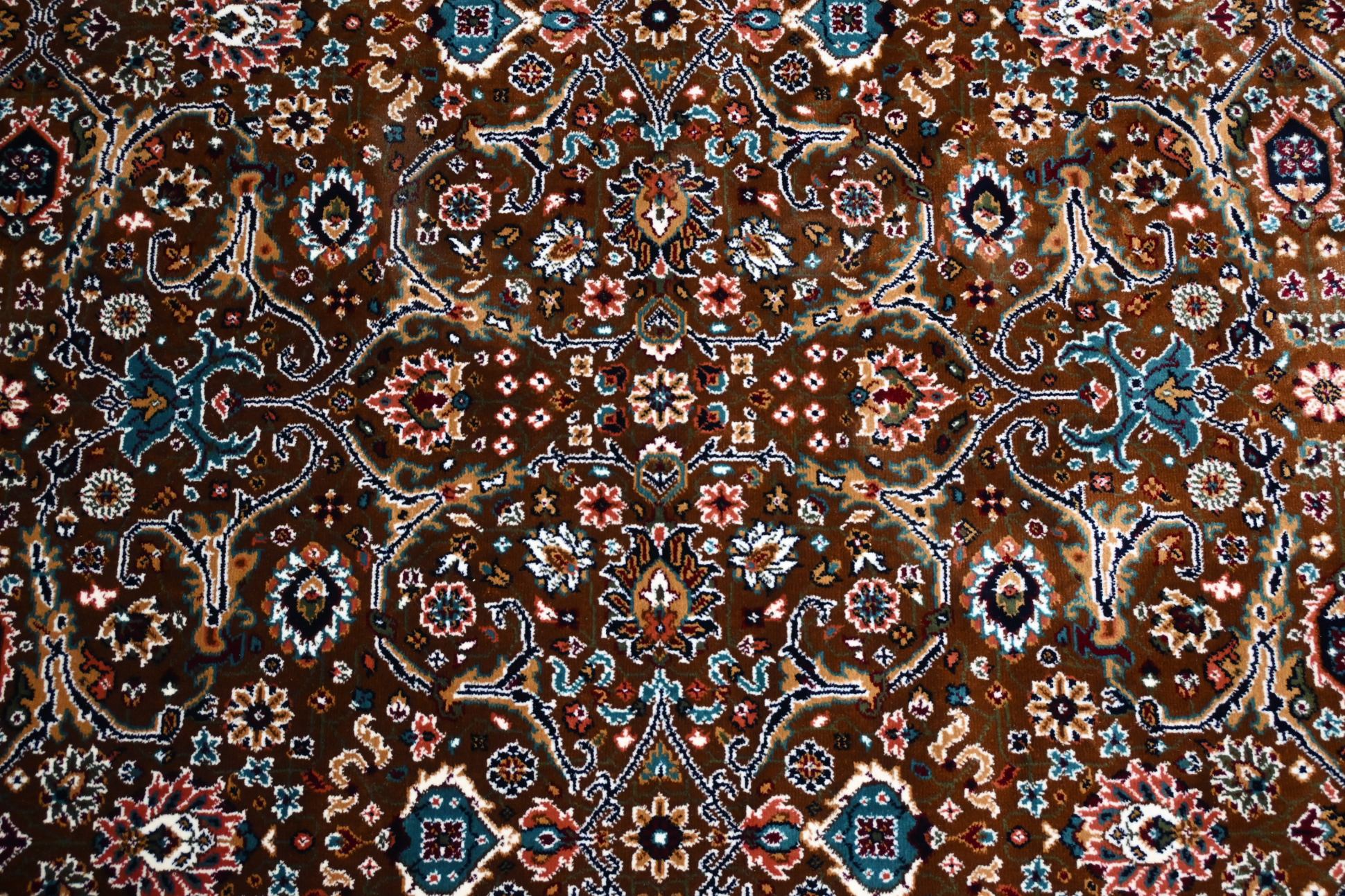 Naqsh Persian rug centre — dense all-over floral arabesque pattern in warm brown, teal, rose and ivory