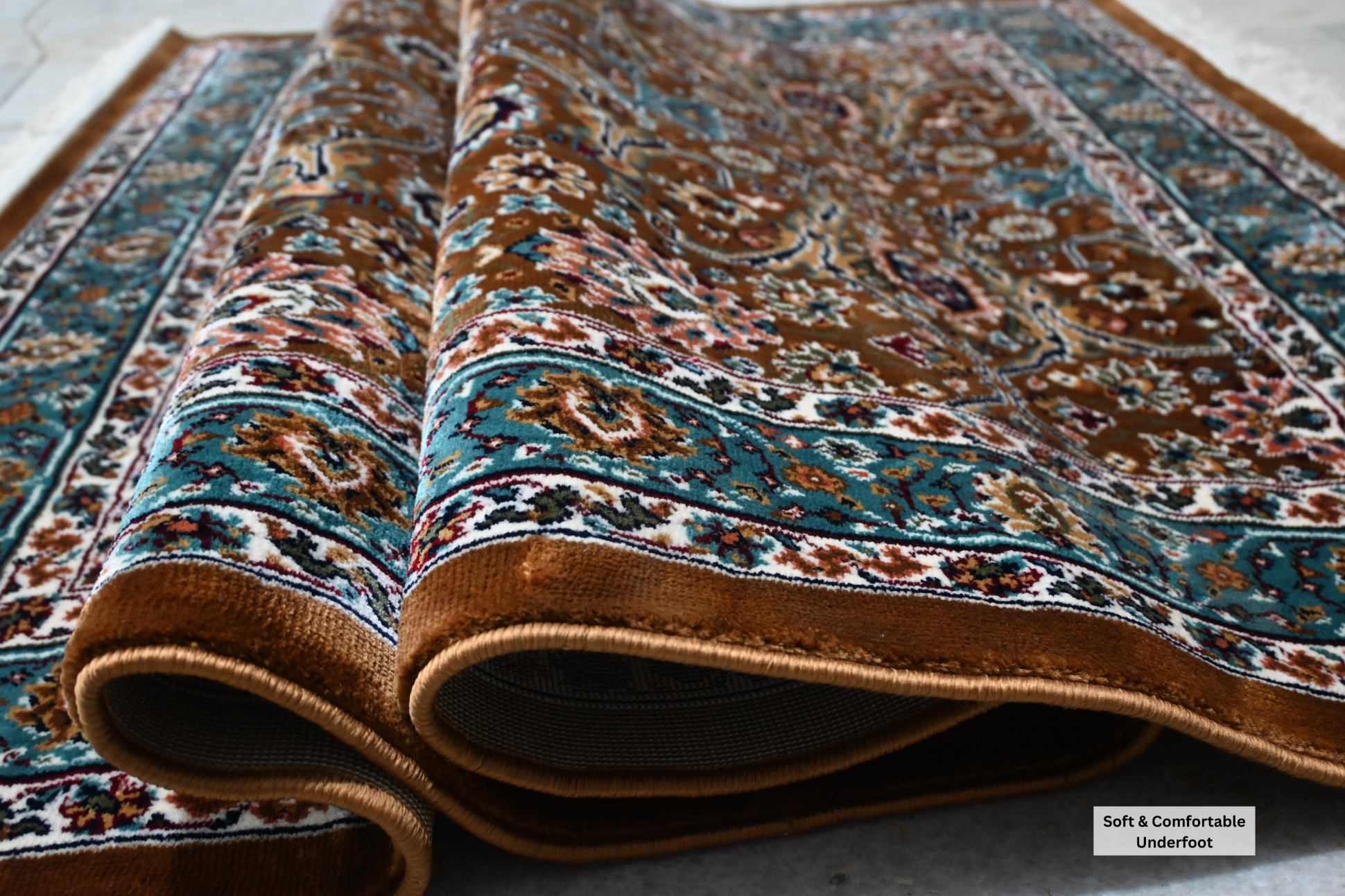 Naqsh Persian rug folded showing soft acrylic wool pile, deep teal border detail and plush comfortable texture