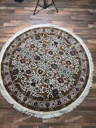 Full overhead view of Zarqaya round Persian-inspired floral rug in ivory, brown and teal with decorative borders and fringe - RugNoor