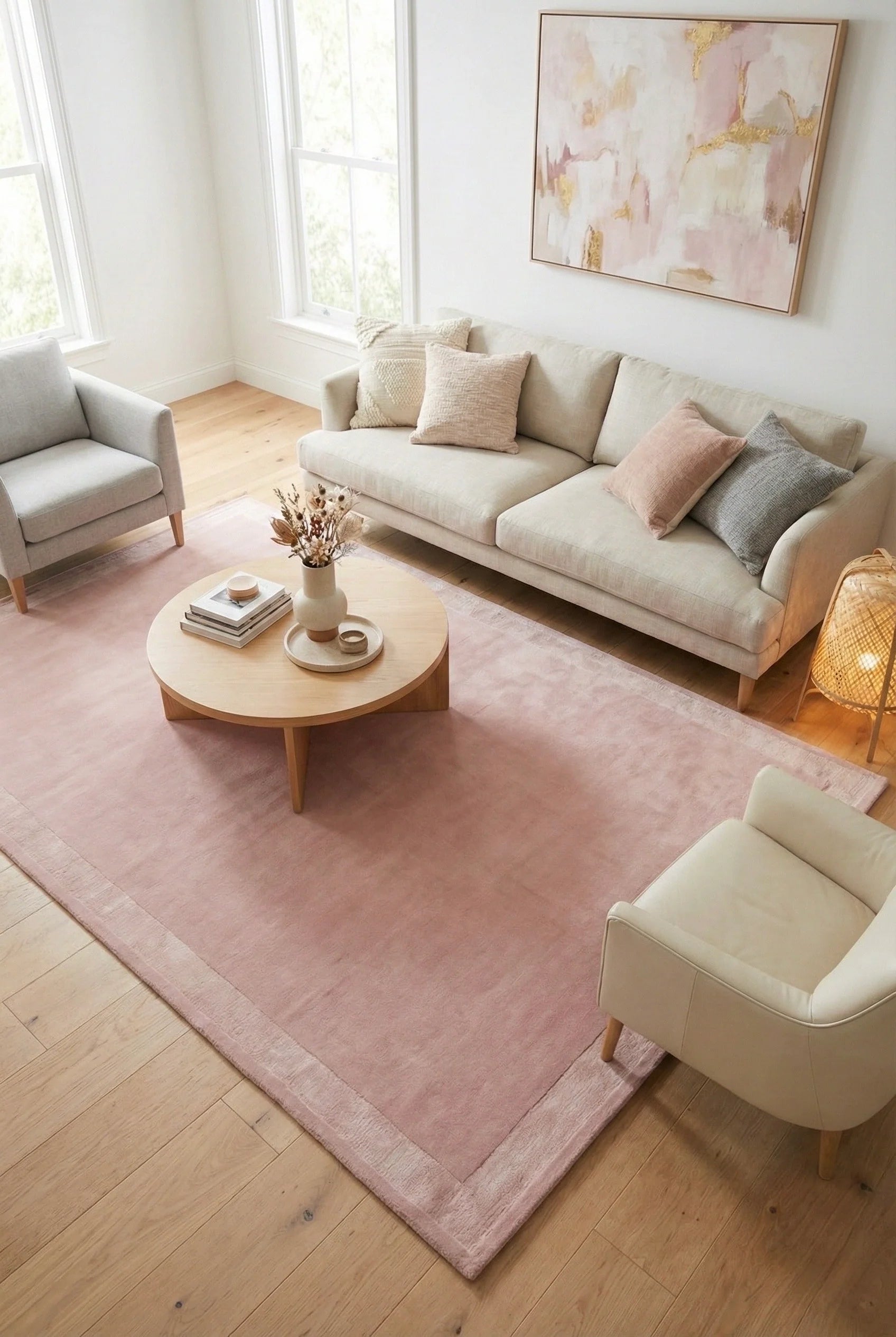 Blush pink hand-tufted border rug styled in bright living room with beige sofa