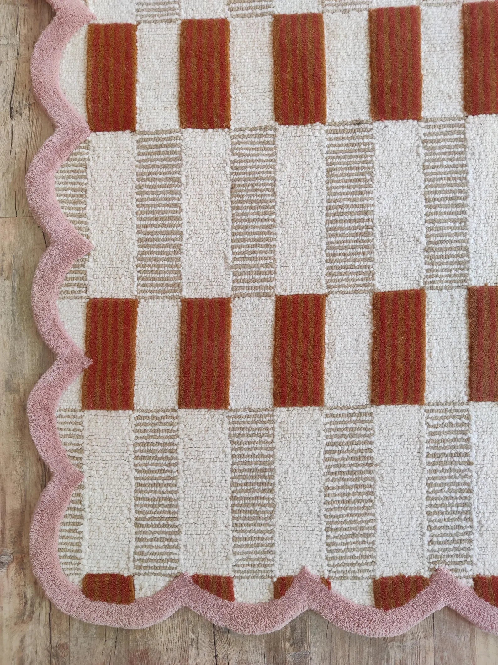 corner of pink scalloped rug carpet