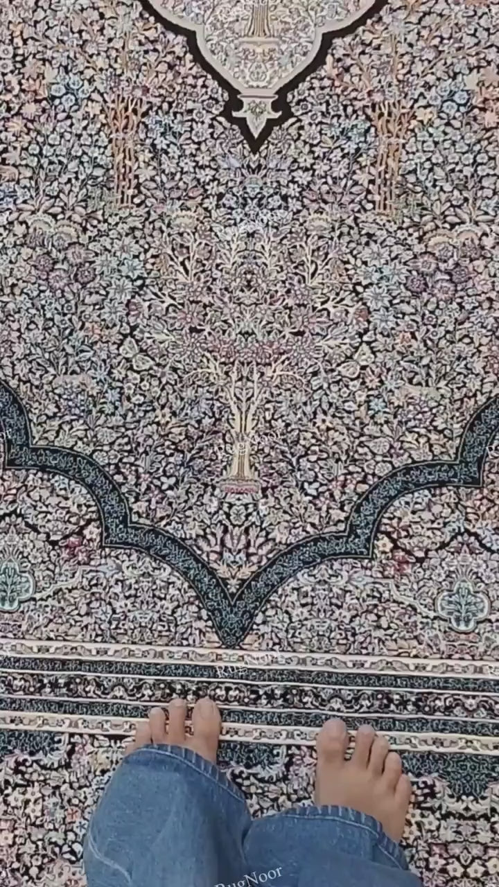 Close-up of the Azrinah ivory medallion carpet showing detailed ornamental motifs in dusty blue, blush pink, rust, muted gold, and dark navy-black.