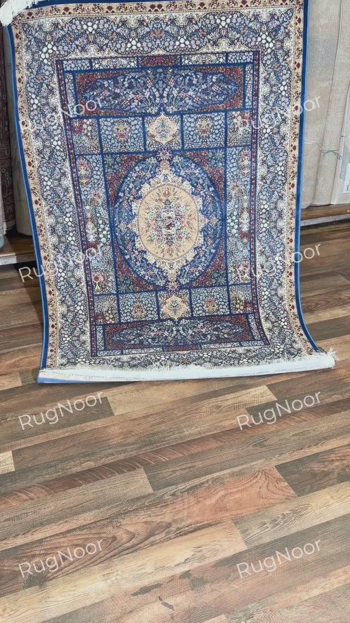 Full view of Nayrizan's navy blue carpet with an oval floral medallion and layered borders.