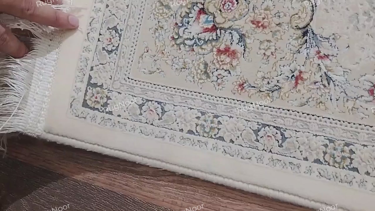 Folded corner of the Mehravi 5x7 traditional ivory floral carpet showing the reverse side, edge finish, fringe and patterned surface.