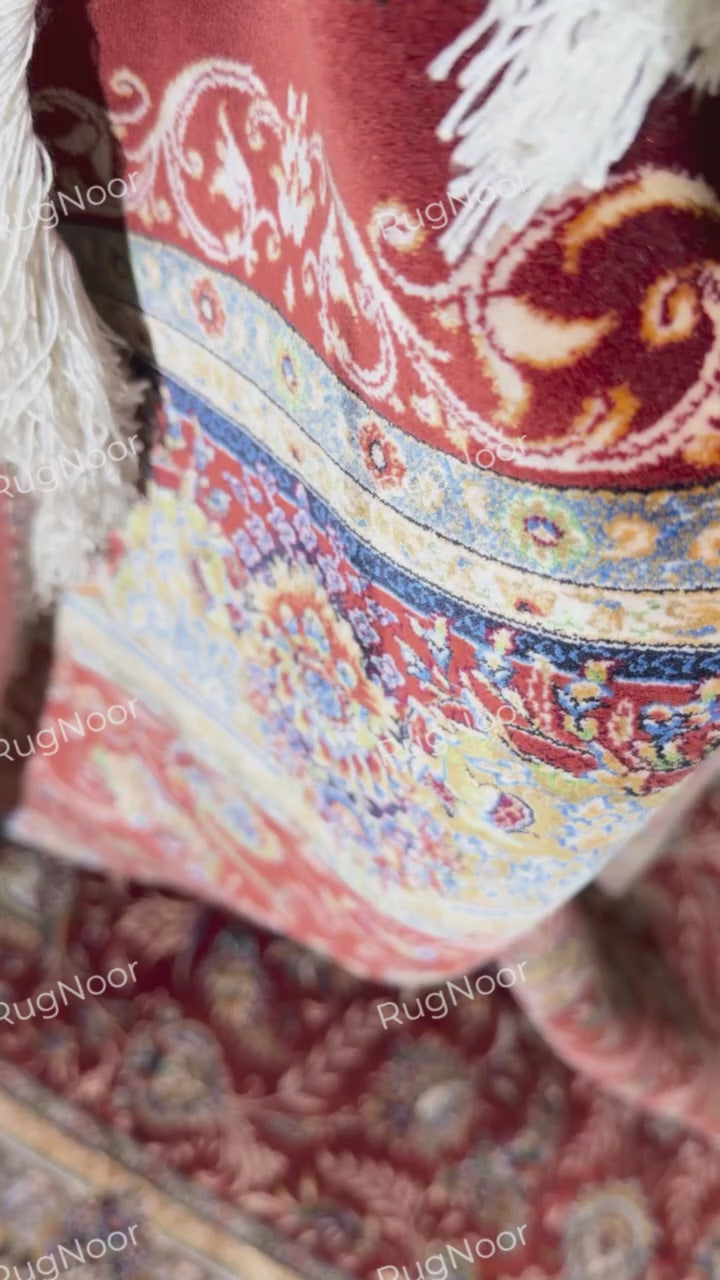 Close-up of Atashgul's pale blue and gold floral border beside the terracotta field.
