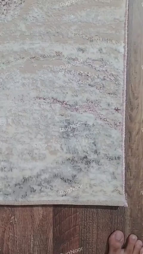 Video showing a close-up of the Rovelle rug's finished edge, its underside backing, and its textured front surface.