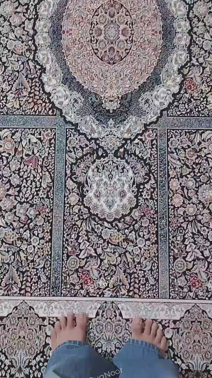 Close-up of the Shabrang traditional floral carpet showing intricate ivory, pale blue, blush pink, and muted gold motifs against a deep black ground.