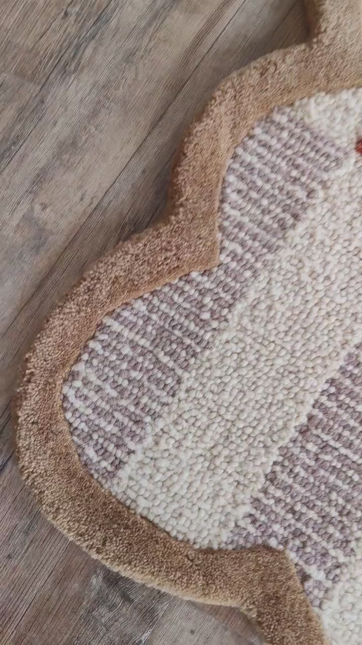 Hand-tufted wool rug featuring a cream and taupe basketweave check accented with rust-orange blocks, bordered by a warm camel scalloped edge — a graphic, textural silhouette that suits both classic and contemporary interiors.