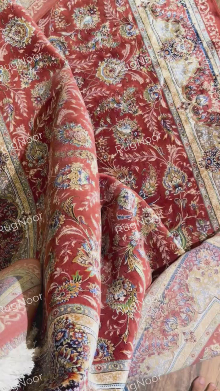 Atashgul rug lifted by its fringed edge, showing the underside and layered border.