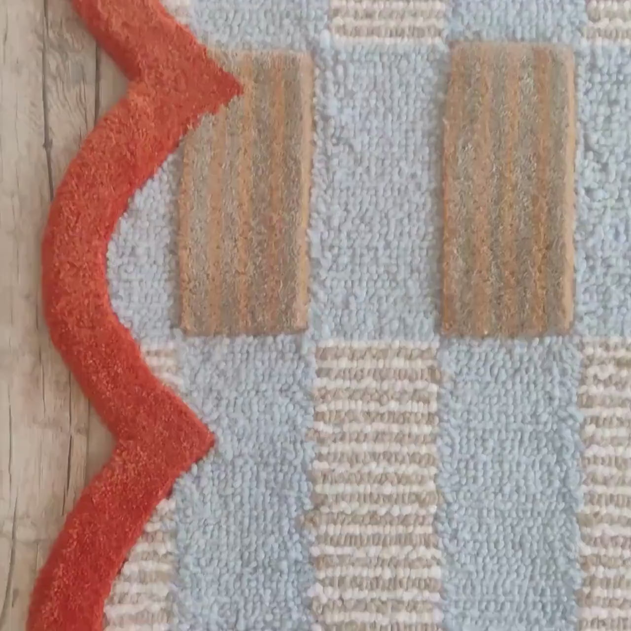 Powder blue and cream woven check bordered by a rich terracotta scalloped edge — a tonal field with a warm contrast frame.