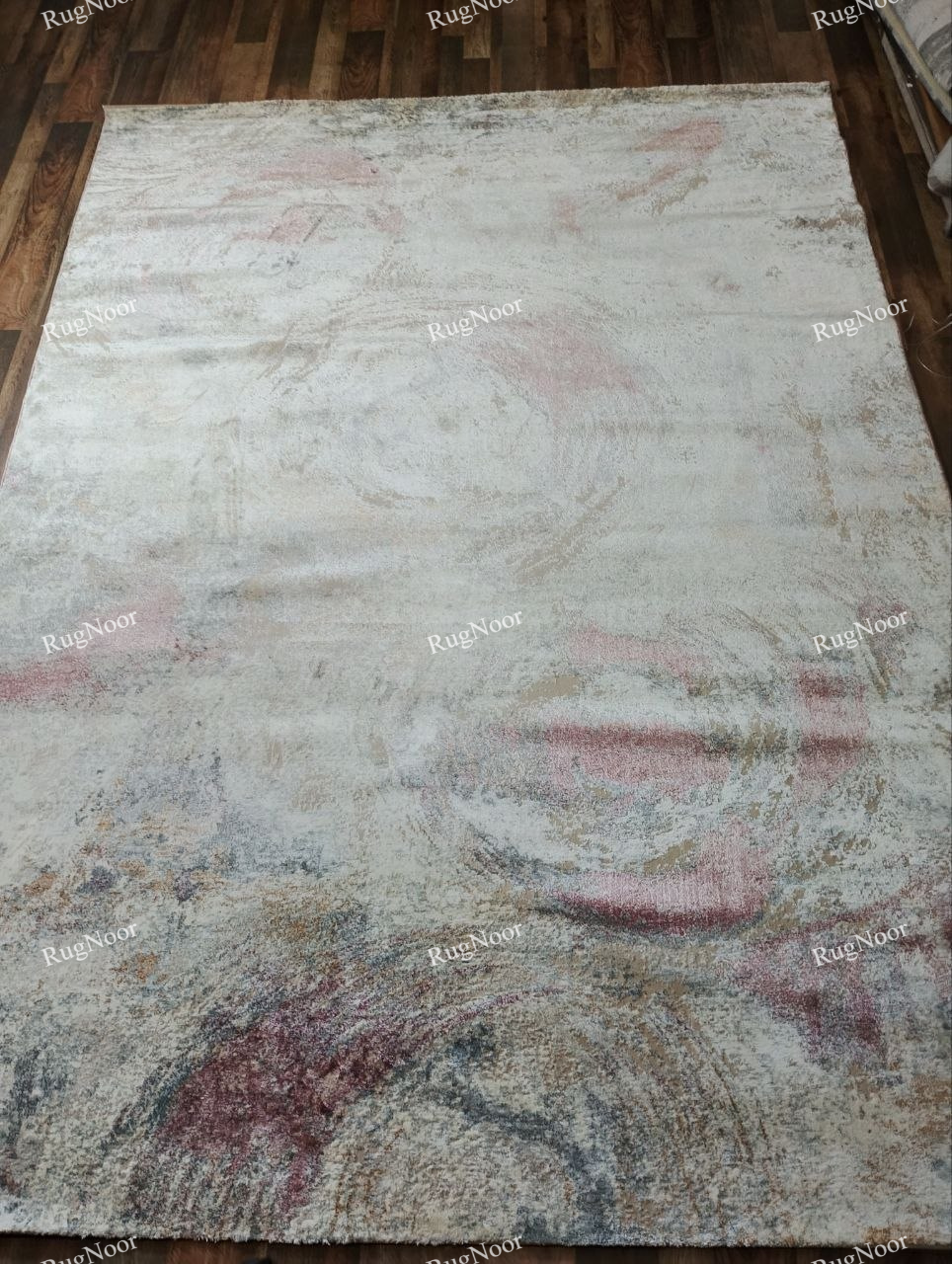 Full front view of the 8 × 11 ft Rovelle modern abstract rug showing its complete swirling pattern in ivory, beige, dusty rose and muted brown.