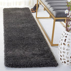 Dark gray shaggy rug in a living room setting with a bench and decorative items.