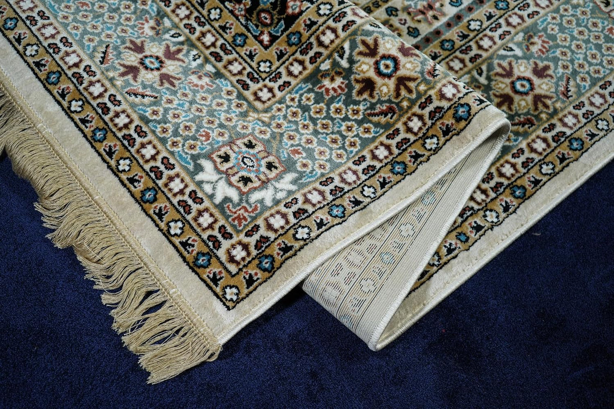 Safir Royal Medallion Rug folded to show its ornamental border, finished edge and fringe