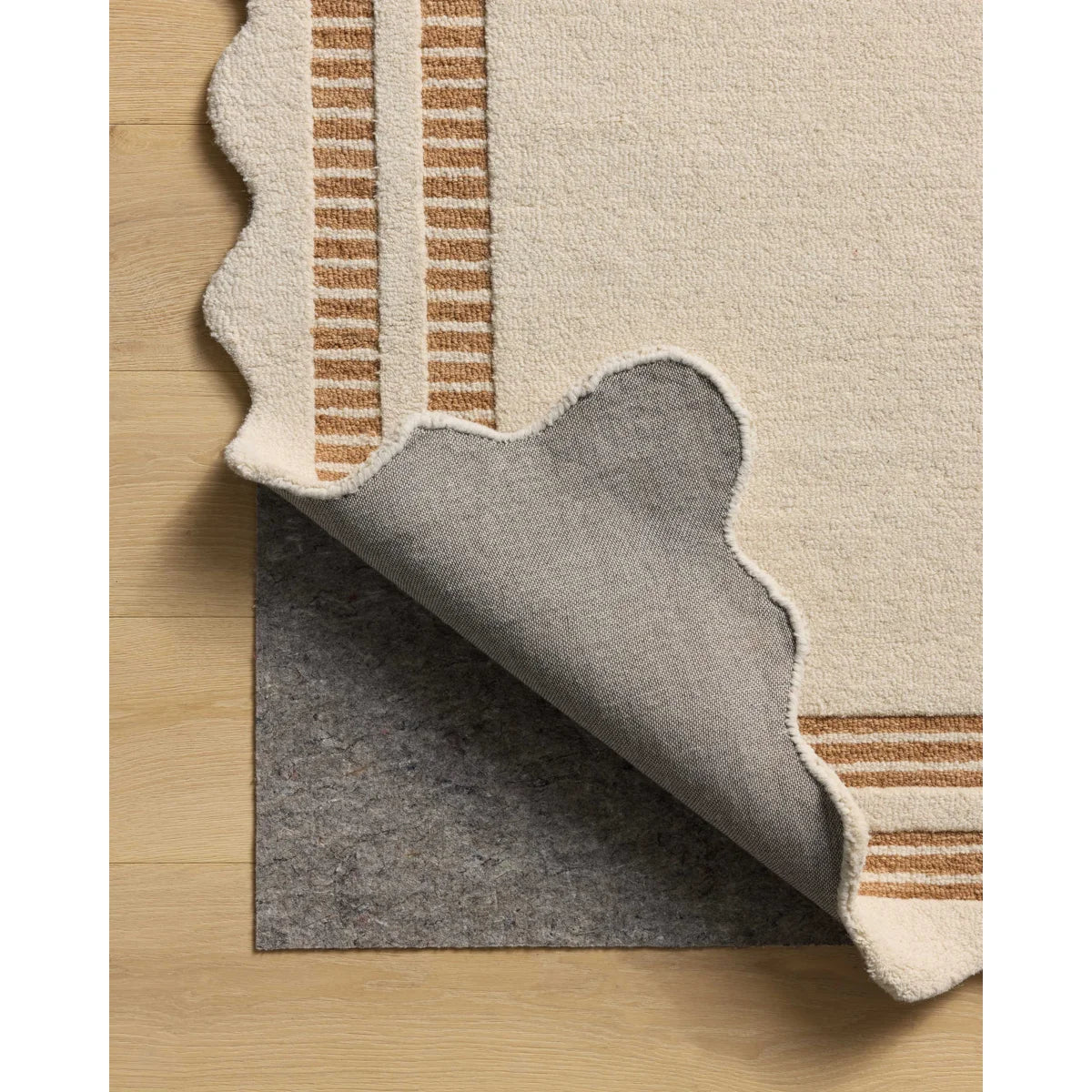 Close-up of a rug with a textured border on a wooden floor.