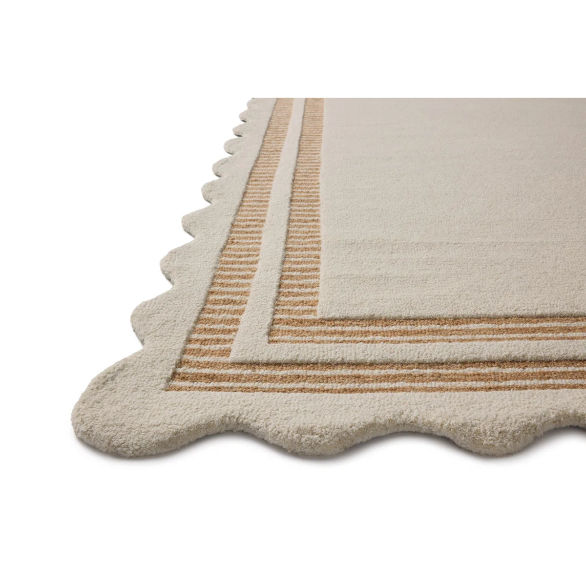 A close-up of a cream-colored area rug with a scalloped edge and a striped border in warm tan and beige, shown on a plain white background.