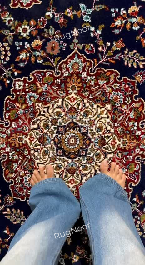 Close-up of Tiraj round navy floral rug showing intricate motifs, ivory fringe, and patterned backing - RugNoor