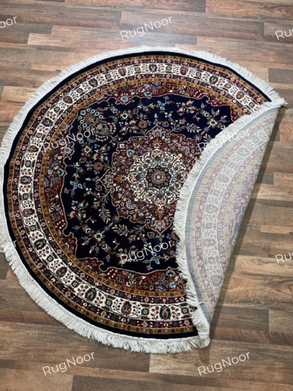 Tiraj round traditional rug folded back to show the patterned underside, ivory fringe, and navy floral surface - RugNoor