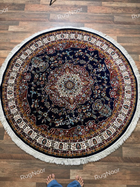 Tiraj round traditional rug featuring dense ivory and burgundy floral motifs on a deep navy field with gold accents and cream fringe - RugNoor