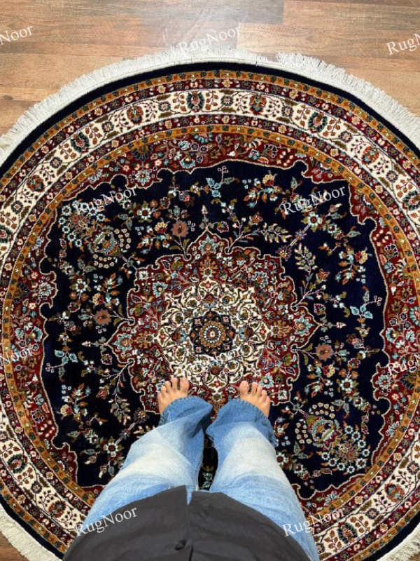 Round navy traditional rug with an ivory floral medallion, burgundy and gold borders, and fringe - Tiraj RugNoor