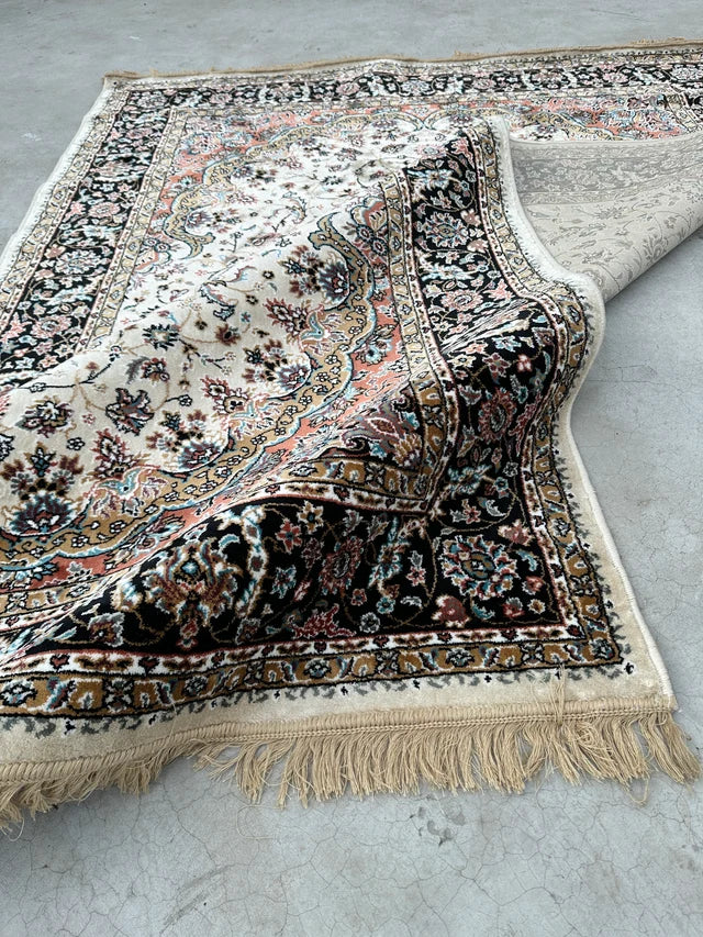 Toranj Royal Medallion Rug folded at the corner showing the patterned underside, finished edge and fringe