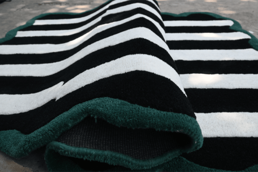 Hand-tufted black and white striped rug with green anti-skid backing – Rugnoor